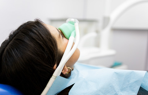 Patient breathing in nitrous oxide in treatment chair