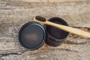 Toothbrush sitting on top of activated charcoal container